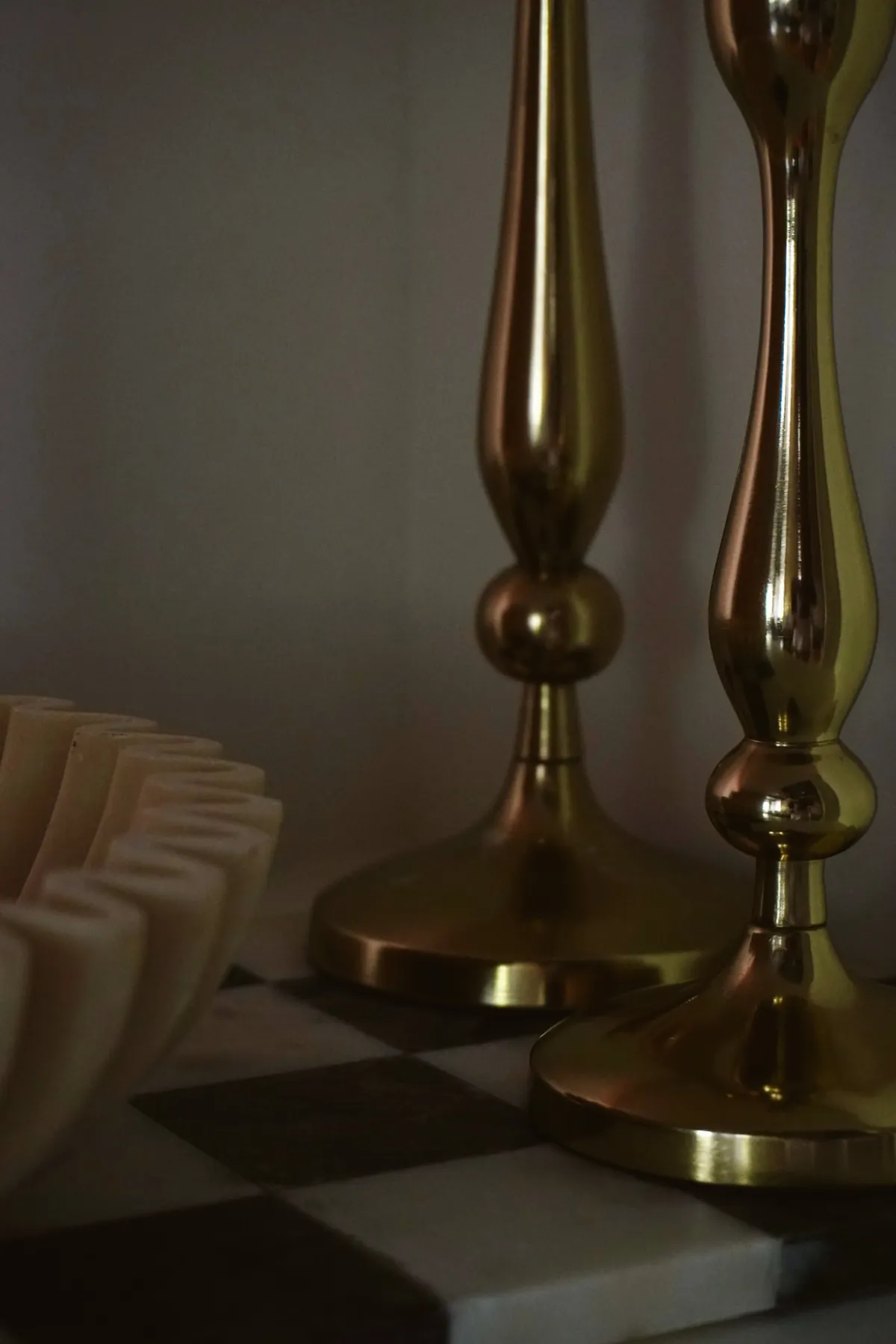 Pair of brass candlesticks on a checkered marble tray
