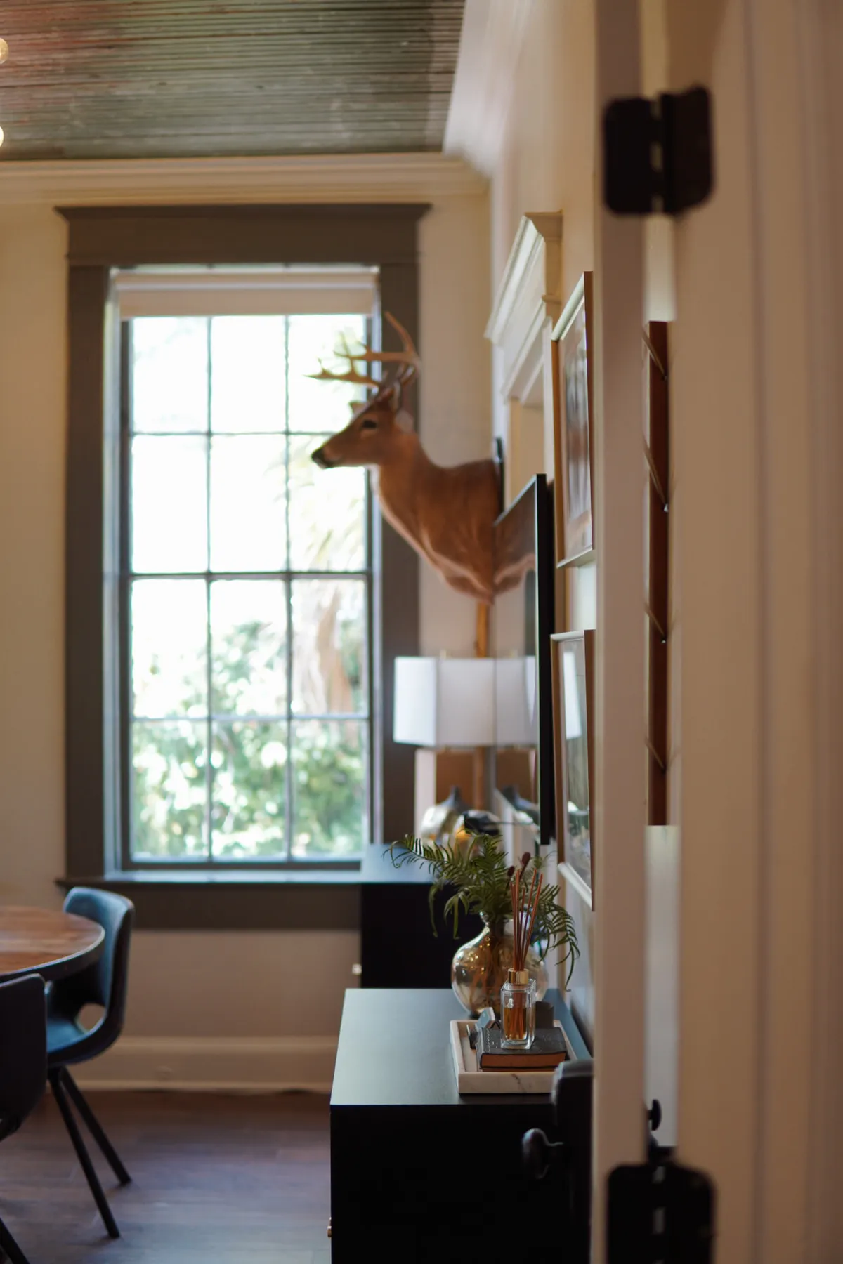 Office entry nook with a console table, framed art and a sunlit window