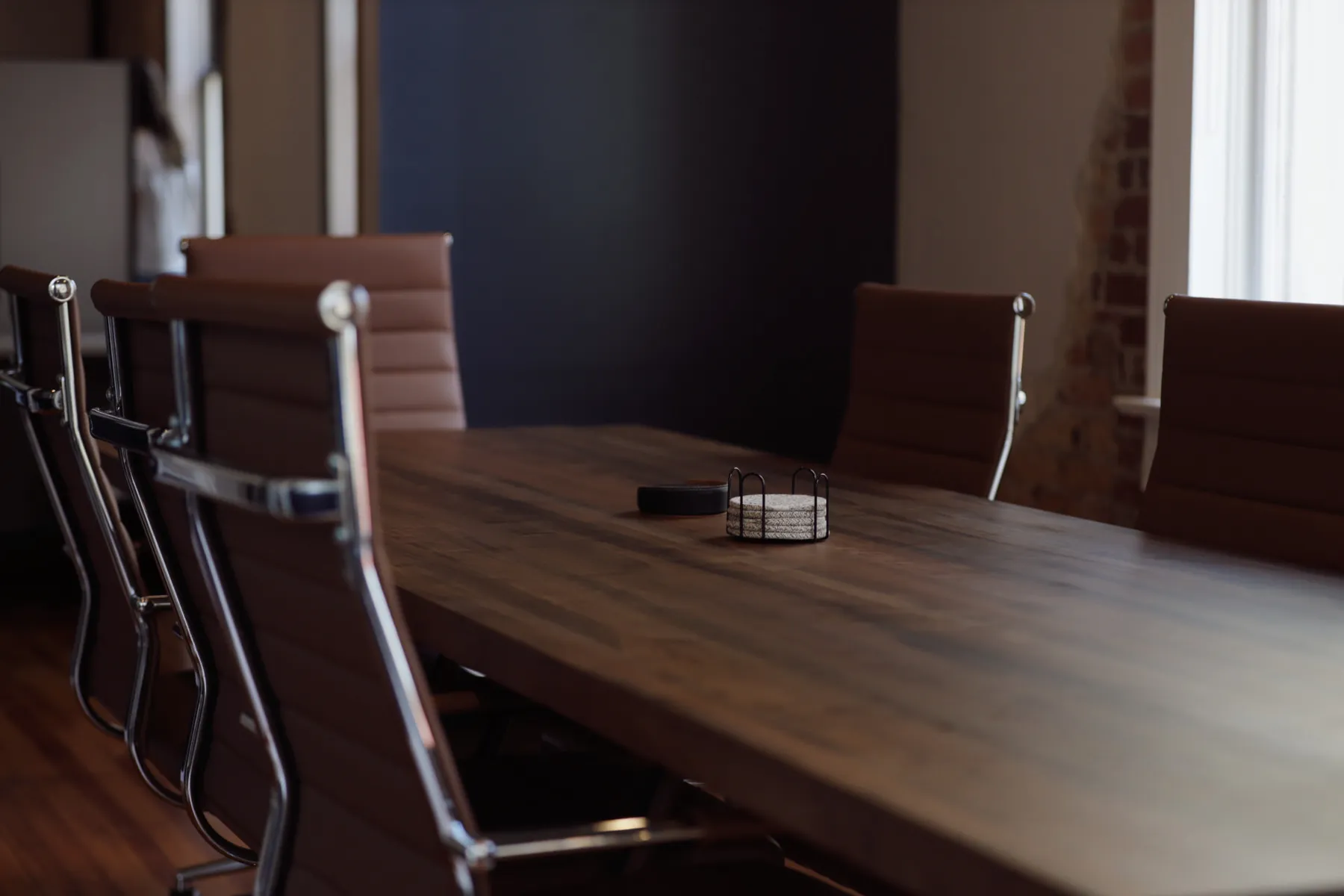 Conference room with a long walnut table and chrome-framed leather chairs